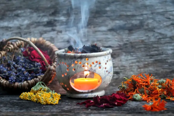Aromas de lavanda, rosas y caléndula se elevan con el humo de un quemador de incienso, creando un ambiente de limpieza de energías.