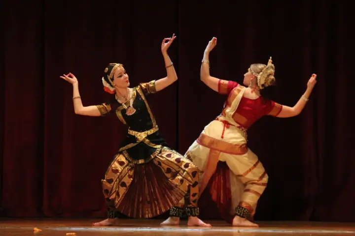 Anna Łopatowska i partnerka w tradycyjnych strojach tańczą taniec klasyczny Bharatanatyam.