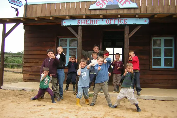 Groupe d'enfants devant un bureau de shérif western.