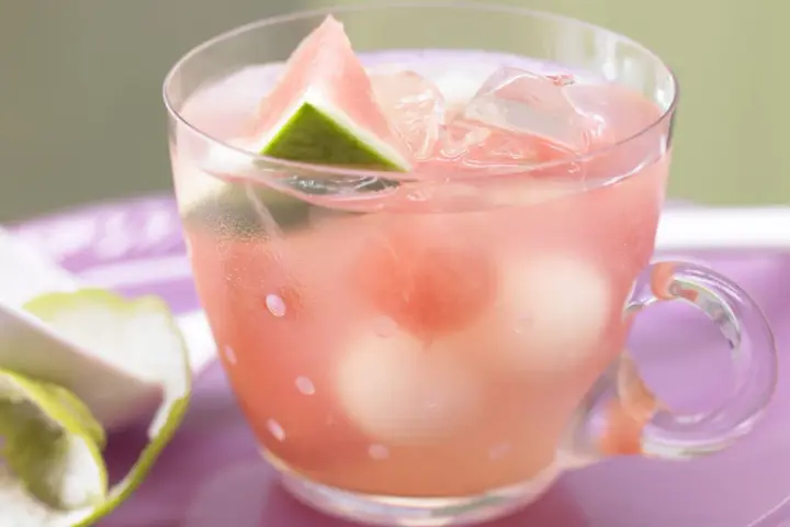 Erfrischende melonenbowle ohne alkohol in einem Glas mit Wassermelonenstücken und Eiswürfeln.