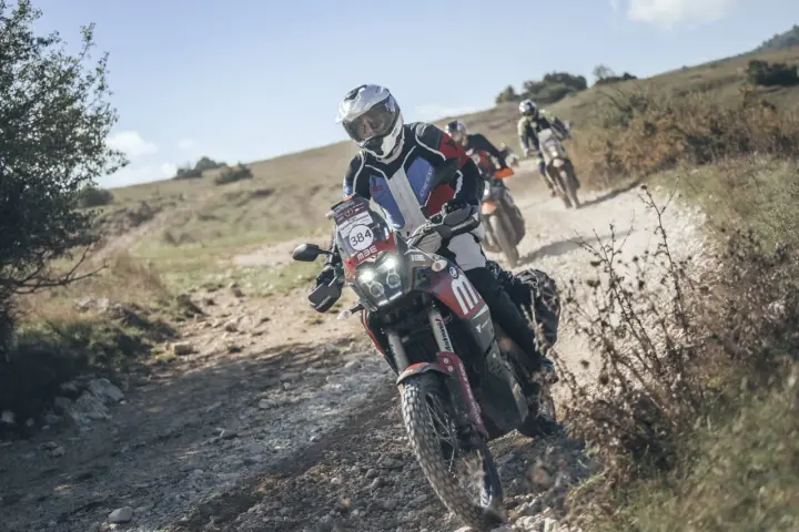 Motociclisti in azione su sterrato, un'emozionante festa bikers sotto il sole.
