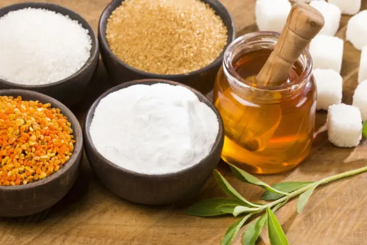 Schalen mit Zucker, Honig, Pollen und Stevia-Blättern – ideale Zutaten für zuckerersatz zum Backen.