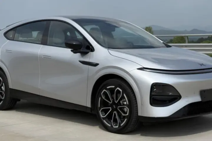 Srebrny SUV XPENG G6 z czarnymi felgami na tle krajobrazu.