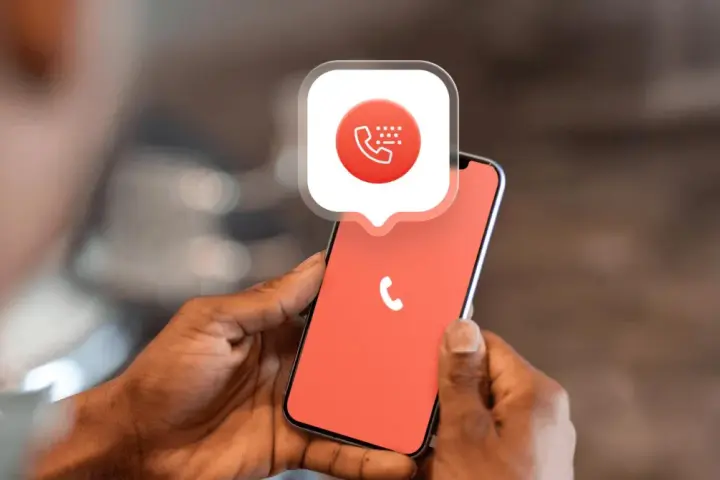 Mani che tengono uno smartphone con un'icona di chiamata e un fumetto. Impara come bloccare un numero privato per la tua tranquillità.
