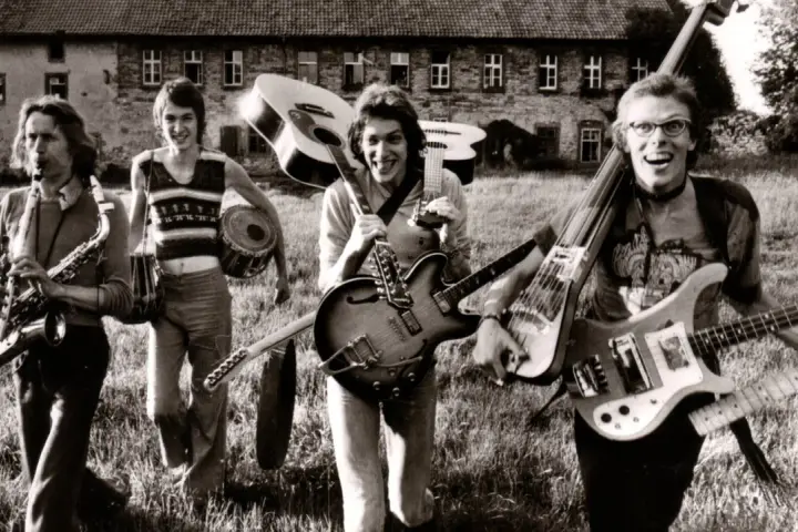 Vier Musiker mit Gitarren und Saxophon, ein Schlagzeuger. Eine Szene, die an deutsche Bands der 70er erinnert, voller Energie und Musik.