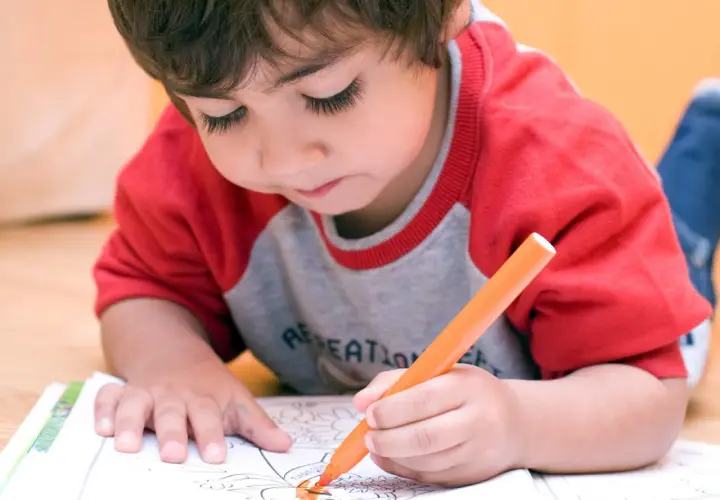 Bambino iperattivo concentrato a colorare, un'idea per cosa fare con un bambino iperattivo.