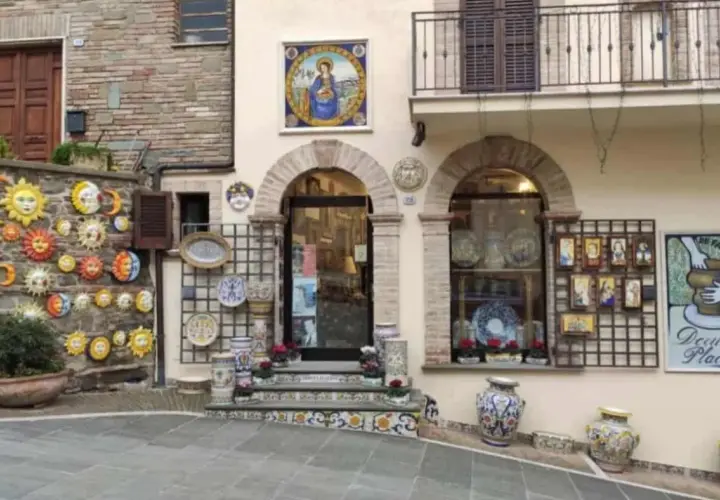 Deruta cosa vedere: bottega di ceramiche con soli, lune, vasi e decorazioni murali.