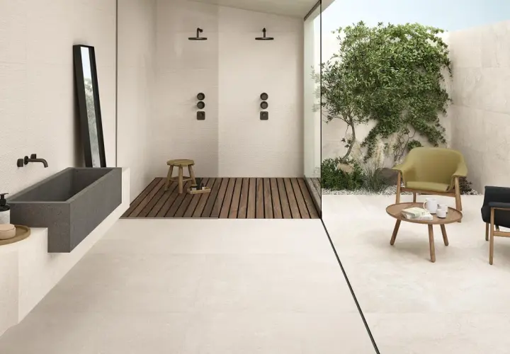 Pavimento casa al mare con vasca in pietra, doccia esterna e zona relax con poltrone.