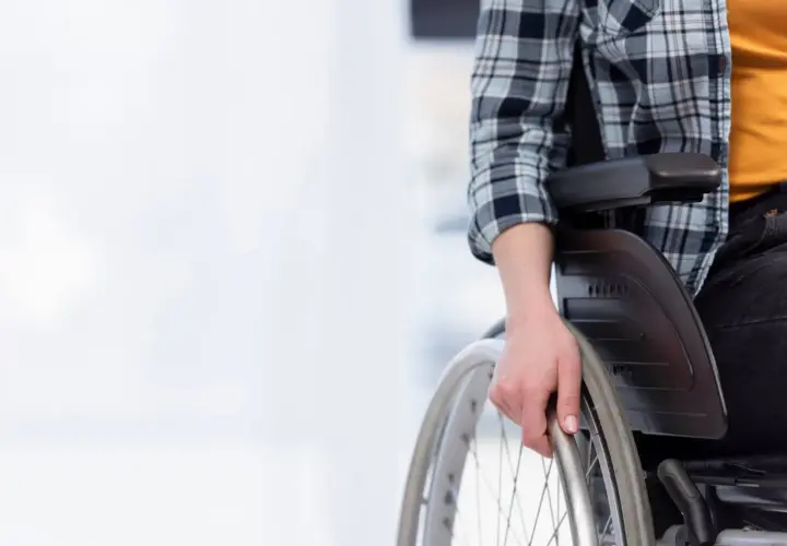 Osoba na wózku inwalidzkim, przygotowująca się do samodzielnego poruszania, symbolizuje nadzieję na godne życie i wsparcie, jakim jest emerytura socjalna.