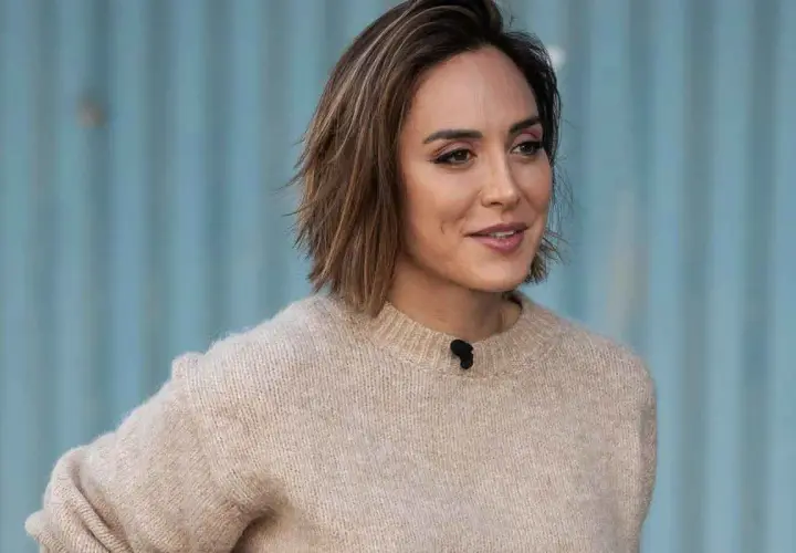 Mujer con un moderno corte pelo bob capas, luciendo un suéter beige y una sonrisa.