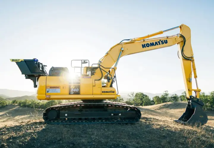 Żółta koparka Komatsu PC 240 LC na wzgórzu. Idealna do leasingu maszyn budowlanych.