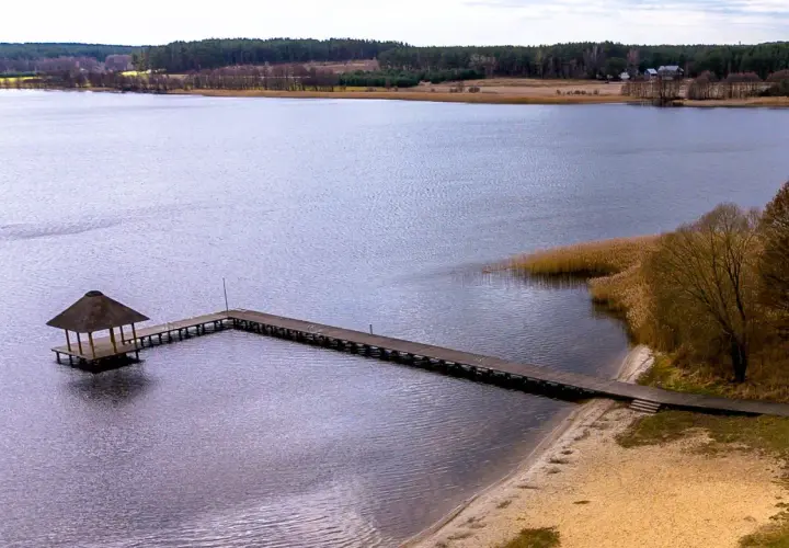Drewniane molo z altaną na jeziorze w Swornegaciach na Kaszubach. Piękny krajobraz jesienny.
