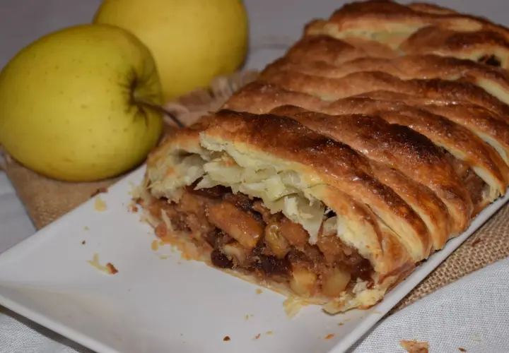 Strudel de manzana con hojaldre dorado y crujiente, relleno de trozos de manzana y pasas. ¡Perfecto para tu próxima receta!