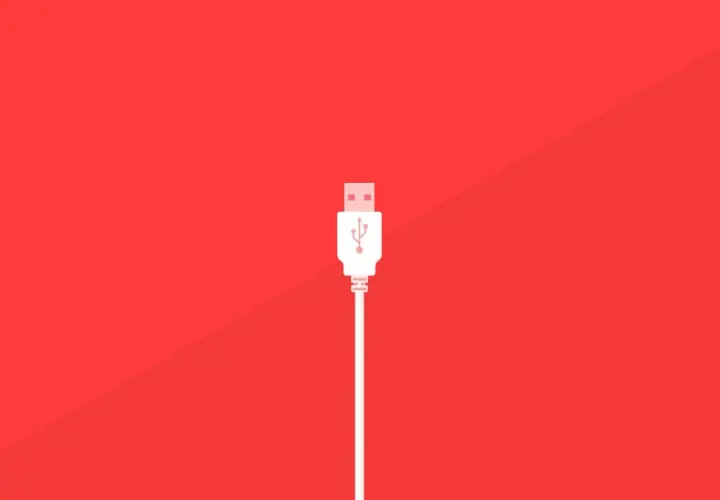 Un conector blanco de varios tipos USB se alza sobre un fondo rojo vibrante, listo para conectar.