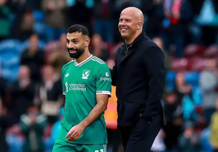 Piłkarz Liverpoolu w zielonej koszulce i łysy mężczyzna w czarnej kurtce uśmiechają się. To może być moment po udanych transferach Liverpoolu.