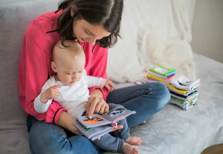 Mama z dzieckiem czyta książeczkę o samochodach. To idealny urlop na dziecko, pełen wspólnych chwil i nauki.
