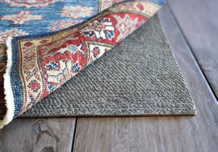 A rug is flipped to reveal its backing, showing how to waterproof a rug with a protective layer.