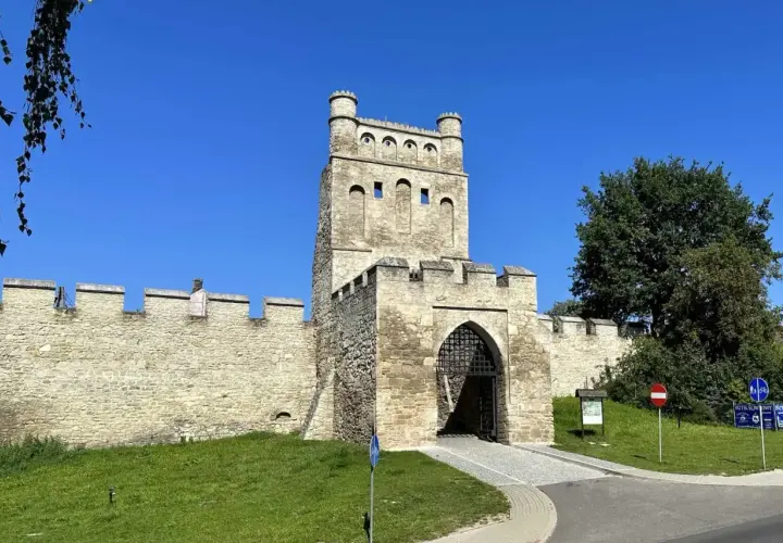 Kamienna brama z wieżą, otoczona murami obronnymi, przypomina polskie Carcassonne.