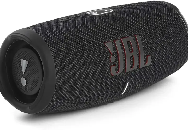 Czarny głośnik JBL z czerwonym logo. Dowiedz się, jak podłączyć słuchawki JBL do telefonu, by cieszyć się muzyką.