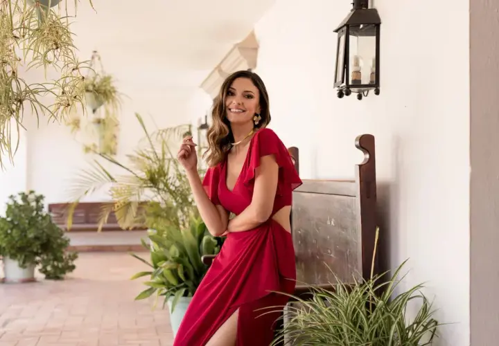 Elegante invitada con semirecogido, ideal para peinados para comunión invitada. Vestido rojo y sonrisa radiante.