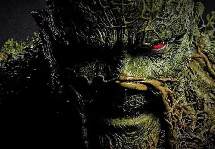 Gros plan sur le visage terrifiant de Swamp Thing, avec son œil rougeoyant. L'image évoque la saison 2 de Swamp Thing.
