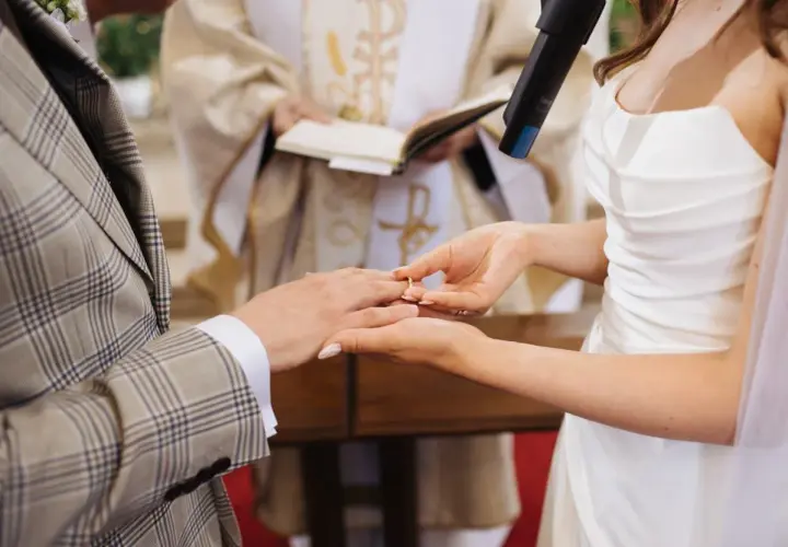 Panna Młoda zakłada obrączkę na palec Pana Młodego. Ceremonia ślub jednostronny w kościele.