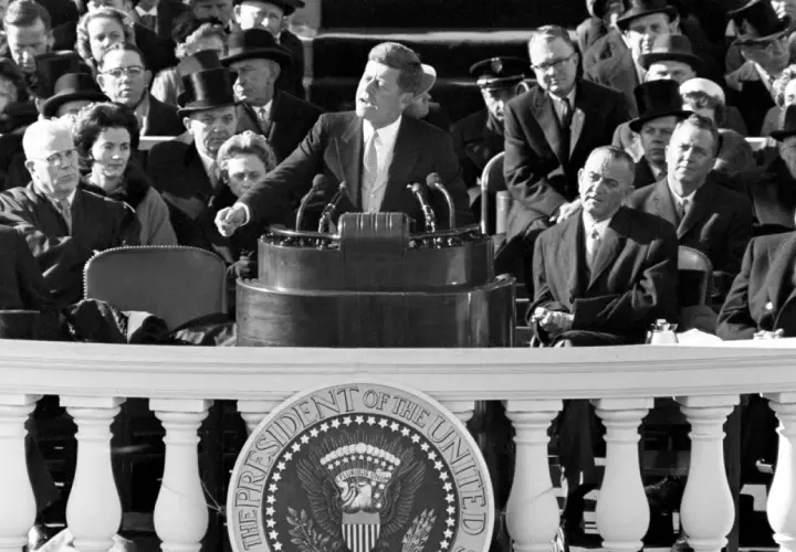 John F. Kennedy's inspiring **leadership style** is evident as he addresses a crowd, embodying youthful vigor and a call to action.