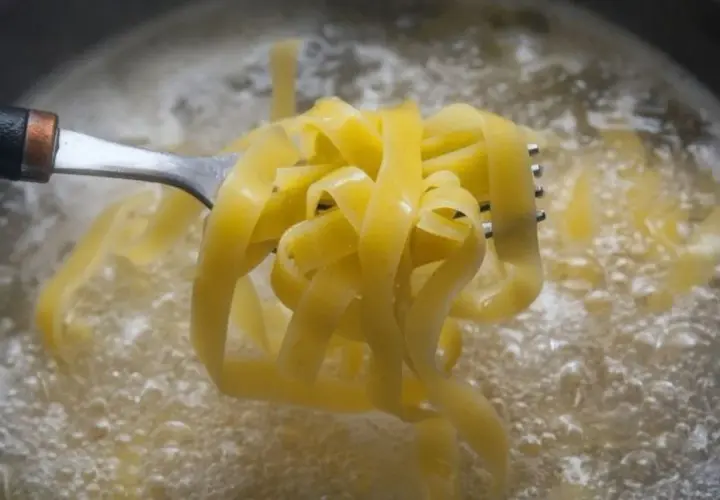 Tagliatelle na widelcu unoszone z wrzącej wody. Prosty sposób, jak ugotować makaron idealnie al dente.