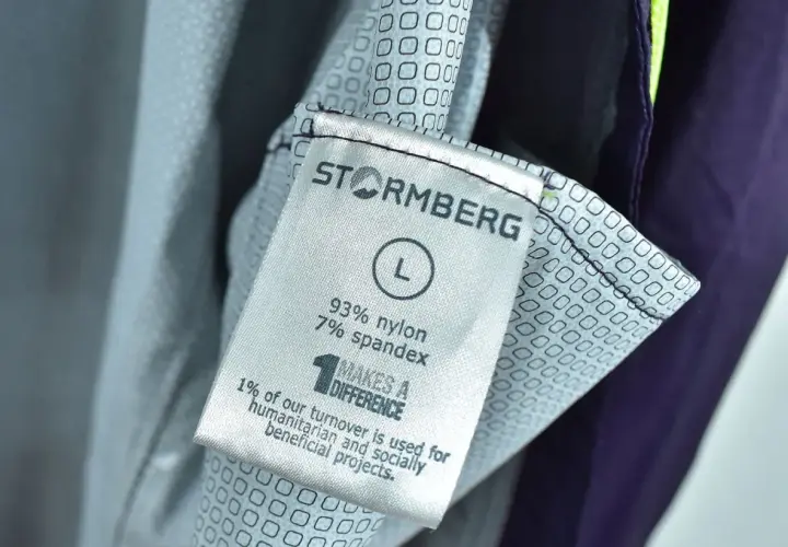 Metka odzieży marki Stormberg, firmy wspierającej projekty humanitarne. Rozmiar L, skład 93% nylon, 7% spandex.