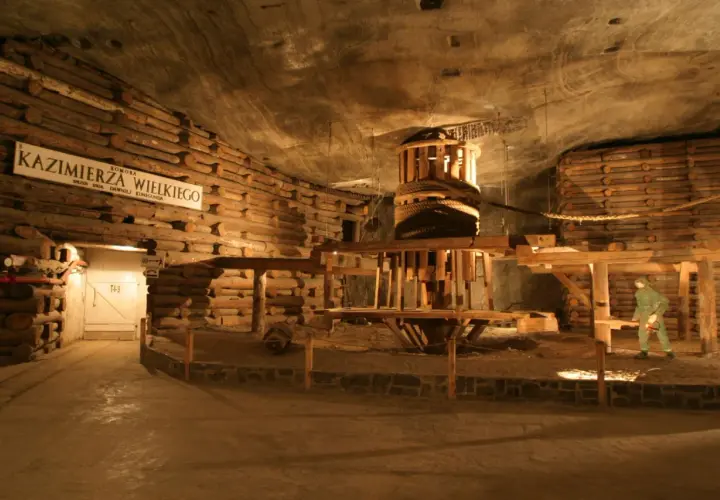 Wieliczka bilety grupowe: ekspozycja dawnej kopalni soli z drewnianą maszynerią i postacią górnika.