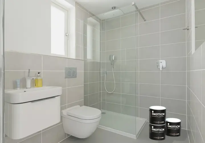 Bagno moderno con piastrelle grigie, doccia a filo pavimento e due barattoli di pittura per piastrelle.
