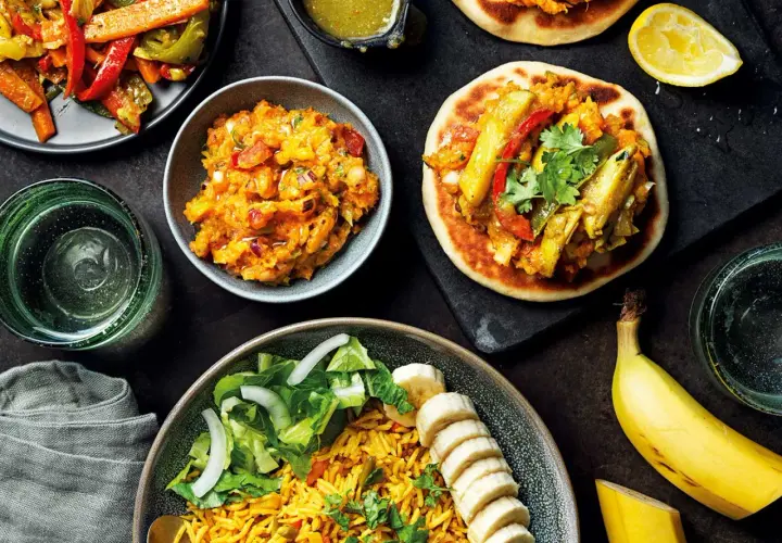 En härlig måltid med somalisk mat: ris, sallad, grönsaksröra och små bröd med fyllning. En banan och en citronklyfta fulländar bilden.
