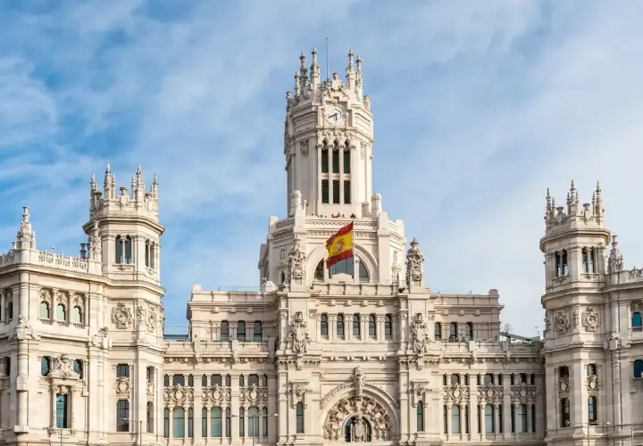 Majestatyczny budynek w Madrycie z hiszpańską flagą, idealne miejsce do studiowania iberystyki.