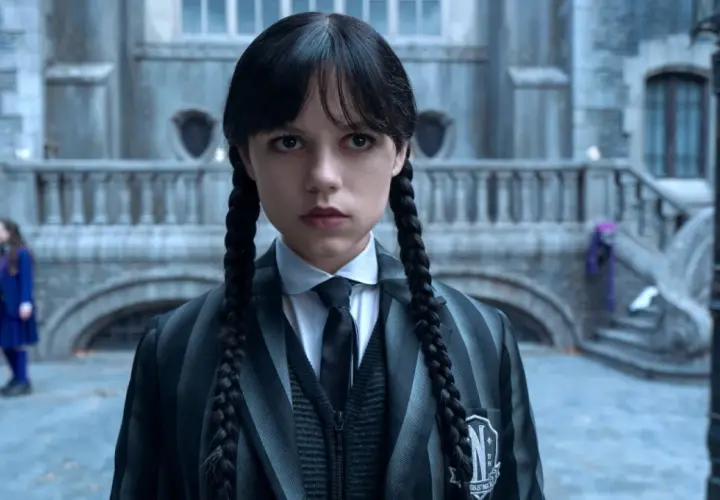 Mercredi Addams, prête pour la saison 2, fixe l'objectif avec son regard intense. L'uniforme de Nevermore Academy est impeccable.