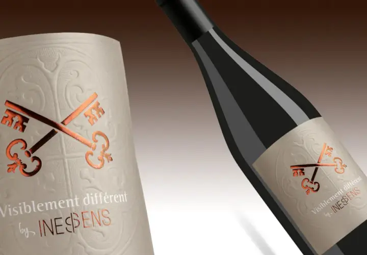 Étiquette de vin avec deux clés croisées, évoquant une pyramide classification des vins. Le texte "Visiblement différent by INESPENS" est présent.