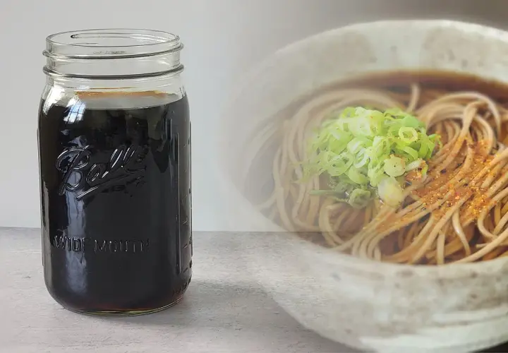 A jar of dark soba dipping sauce sits next to a bowl of soba noodles with green onions. Perfect for your soba dipping sauce recipe.