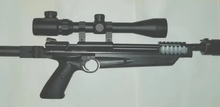 Crosman 1322 z lunetą i tłumikiem, gotowy do akcji.