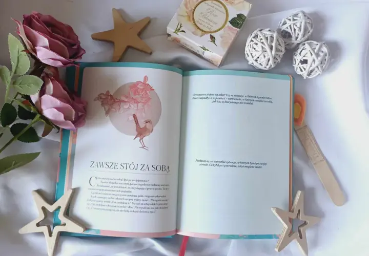 Otwarta książka z cytatem "Zawsze stój za sobą" i dekoracjami. Inspiracja, jak naprawić swoje życie, zaczyna się od wiary w siebie.