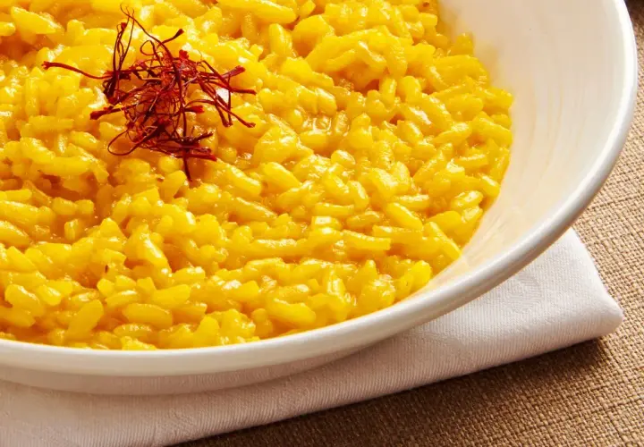 Aksamitne risotto alla milanese, bogato zdobione nitkami szafranu, kusi swoim złocistym kolorem i kremową konsystencją.