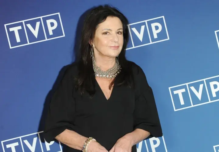 Zofia Czernicka w czarnej kreacji, z okazałą biżuterią, na tle logo TVP. Wiele osób zastanawia się, kim są jej partnerzy.
