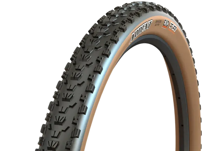 A close-up of a Maxxis Ardent tire with tan sidewalls, ready for a trail review. Its aggressive tread promises grip.