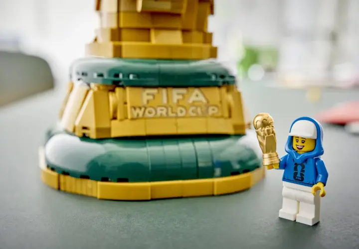 Ein Lego-Männchen mit FIFA-Hoodie hält stolz den goldenen Pokal des Lego World Cup.