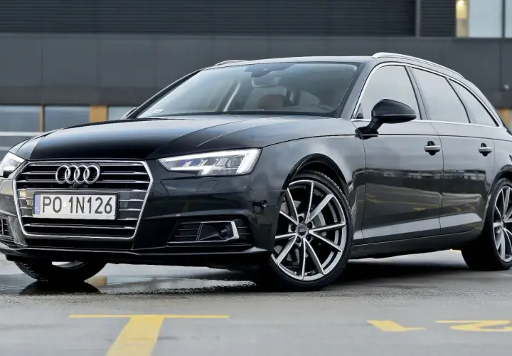 Czarny Audi A4 Avant z tablicą PO 1N126 na parkingu.