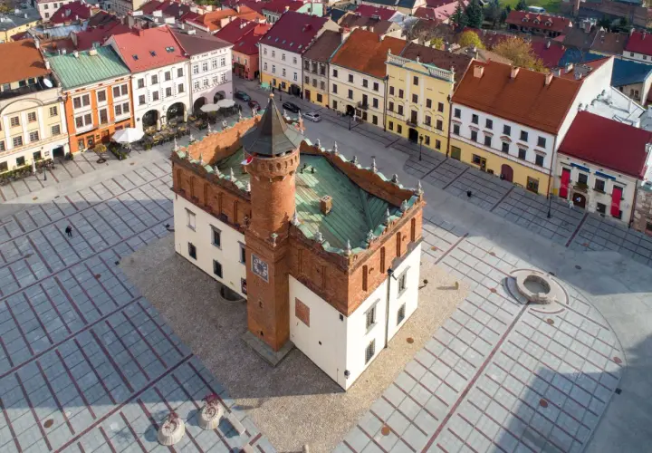 Rynek w Tarnowie, polskim biegunie ciepła, z ratuszem i kolorowymi kamienicami.