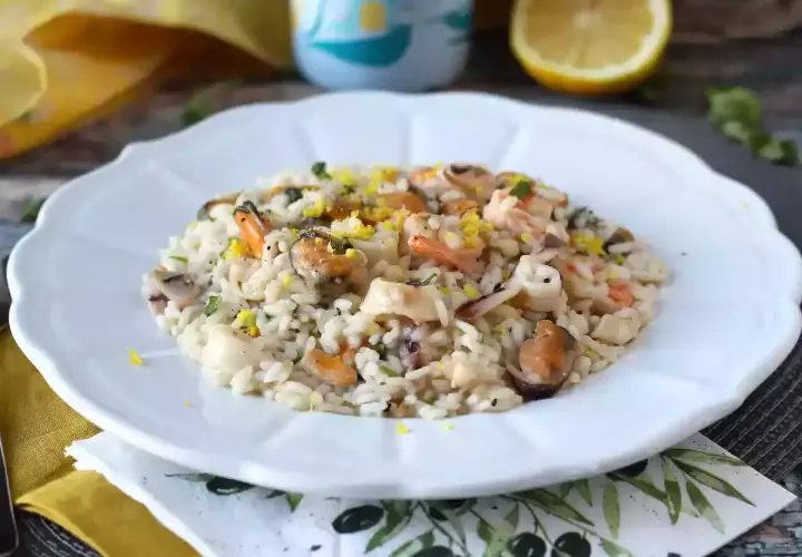 Un délicieux risotto aux fruits de mer, garni de zestes de citron et de persil. Un plat savoureux qui rappelle la mer.