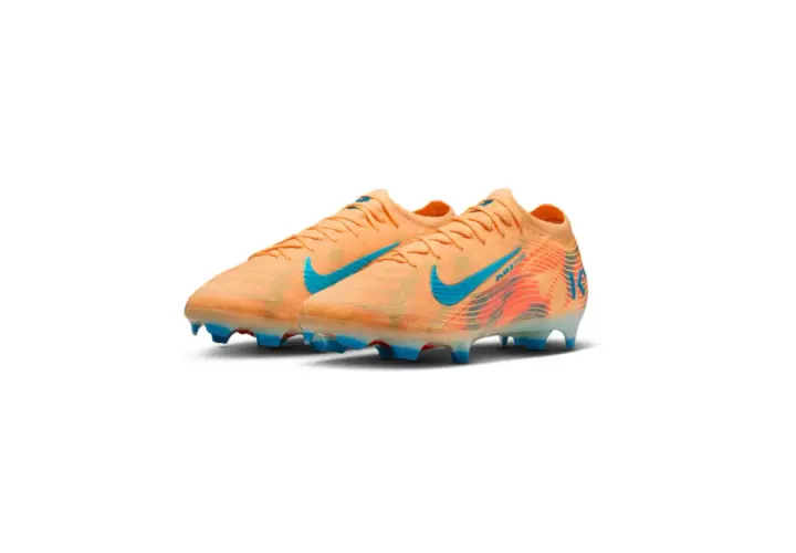 Pomarańczowe korki piłkarskie Nike z turkusowymi detalami i grafiką. To najlepsze korki na świecie dla każdego piłkarza.
