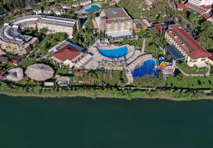 Widok z lotu ptaka na kompleks hotelowy Marvida Family Eco nad jeziorem, z basenami, zjeżdżalniami i terenami zielonymi.