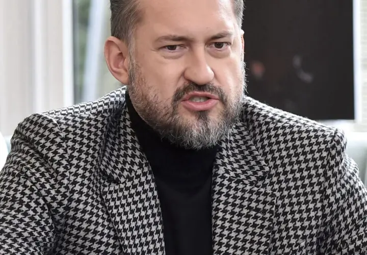 Marcin Prokop w czarnej golfie i marynarce w pepitkę.