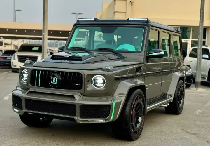 Szary Mercedes Brabus z neonowo-zielonymi akcentami i podświetlanym logo "B" na grillu.