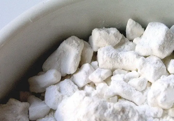 Cumuli bianchi e soffici, simili a zucchero, in una ciotola. Le loro proprietà sembrano invitanti.
